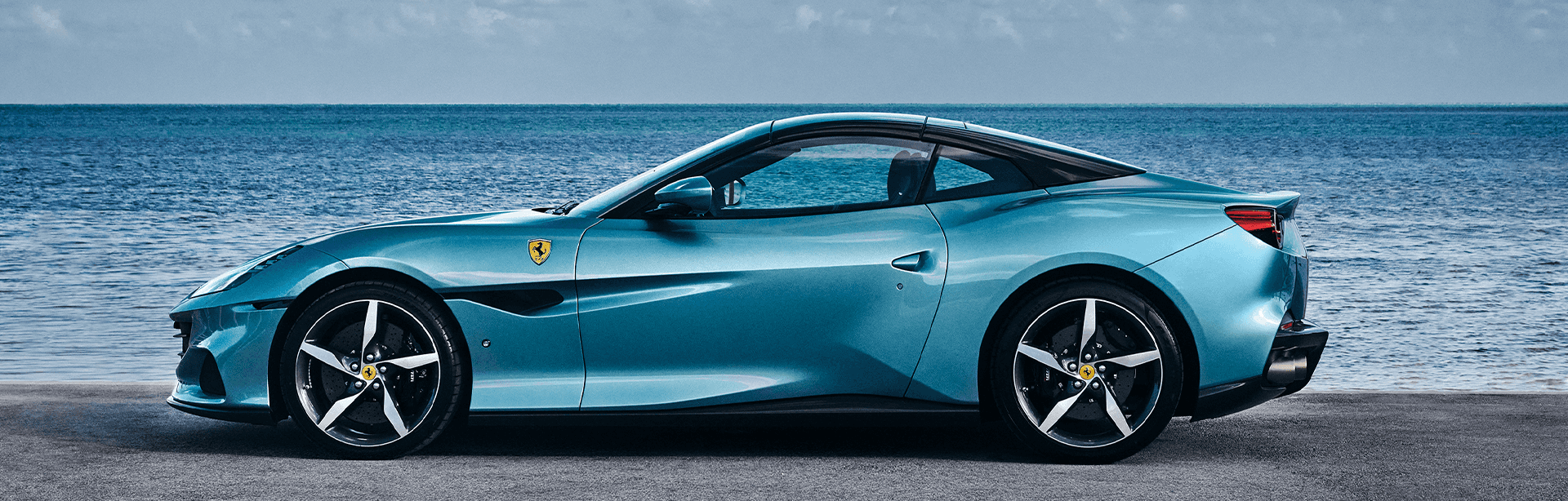 Ferrari Portofino M side view exterior by the ocean