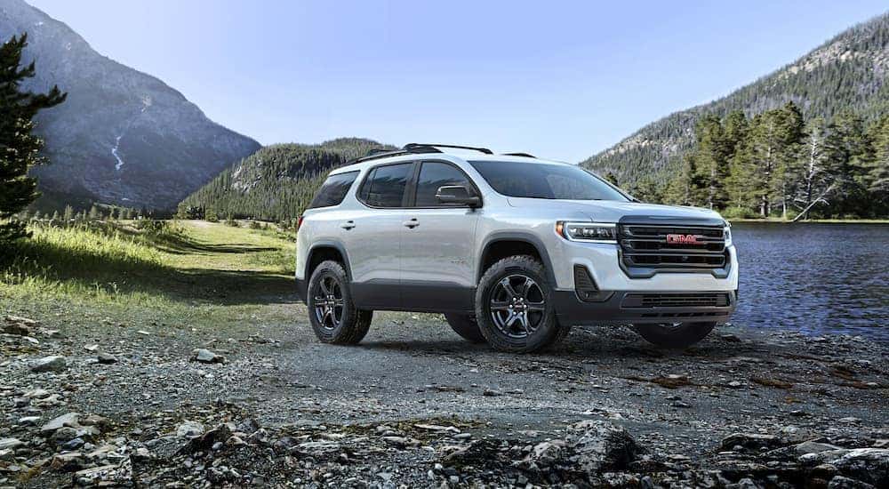 A white 2023 GMC Acadia is shown parked near a lake after visiting a GMC dealer near Lombard.