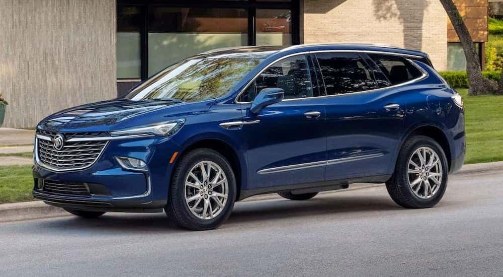 A blue 2024 Buick Enclave is shown parked near a building after visiting a Buick dealer near Lombard.