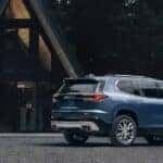 A blue 2024 GMC Acadia Denali is shown parked near a house after visiting a GMC dealer near Lombard.