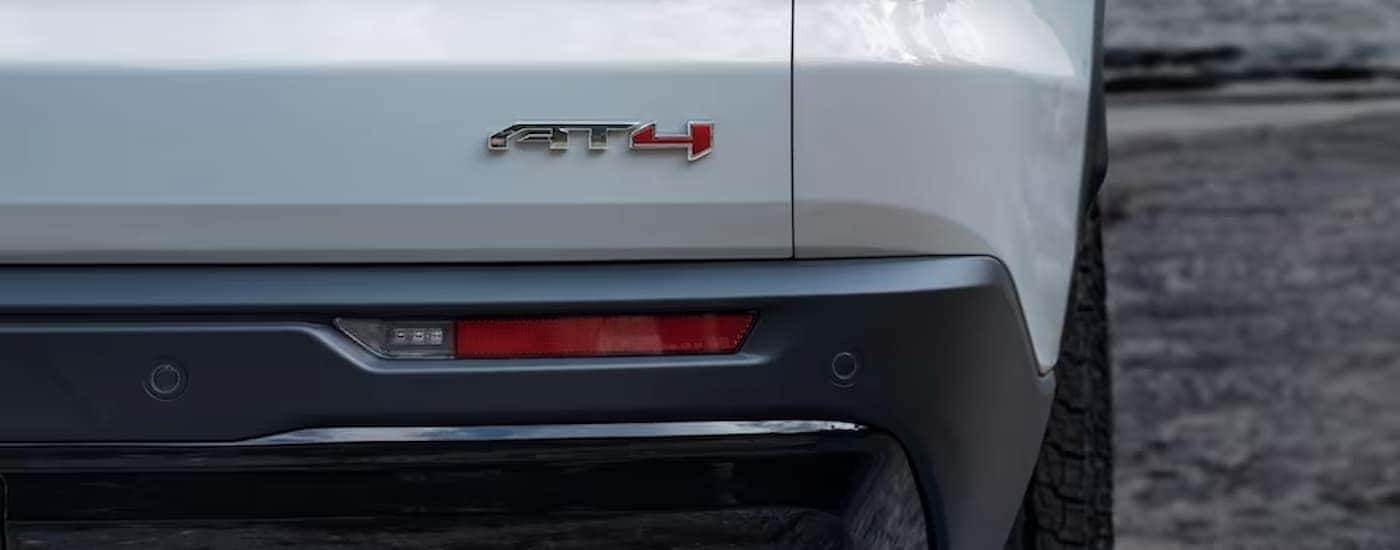 A close up of the rear bumper on a white 2024 GMC Acadia AT4 is shown.