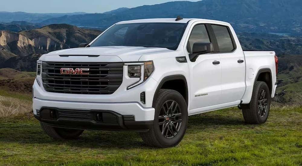 A white 2024 GMC Sierra 1500 SLE is shown parked on grass.