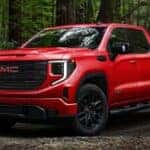 A red 2024 GMC Sierra Elevation parked in the woods.
