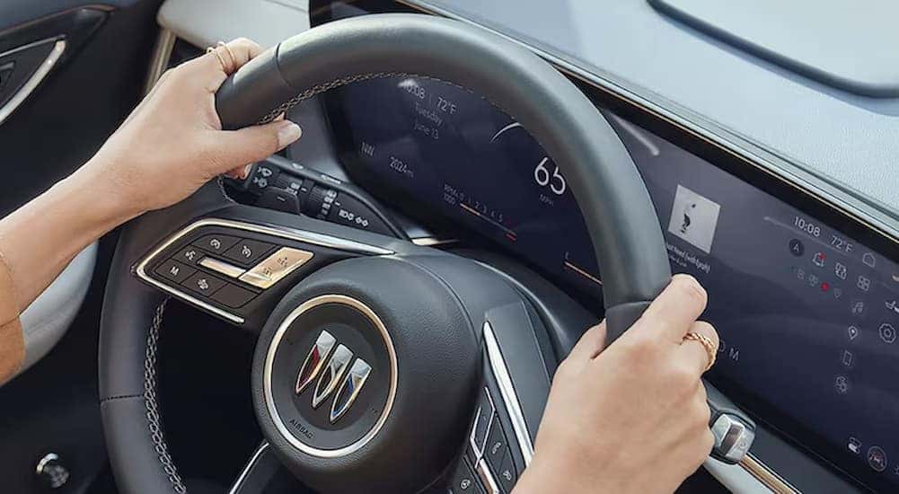 a close-up of the steering wheel and digital dash in a 2024 Buick Envision is shown.
