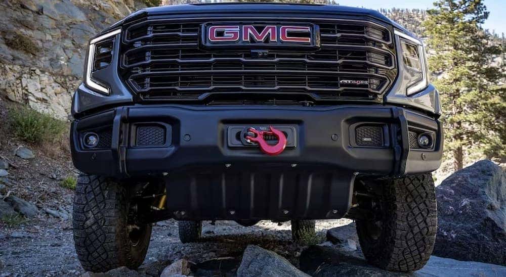 A close-up on the grille of a gray 2024 GMC Sierra 1500 AT4X is shown.