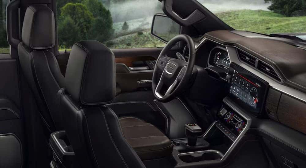 The black and brown interior and dash in a 2024 GMC Sierra 1500 Denali is shown.