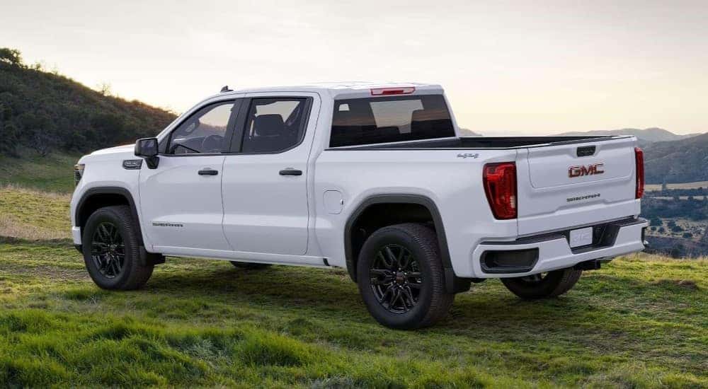 A popular GMC Sierra for sale, a white 2024 GMC Sierra 1500 SLE, is shown parked off-road.