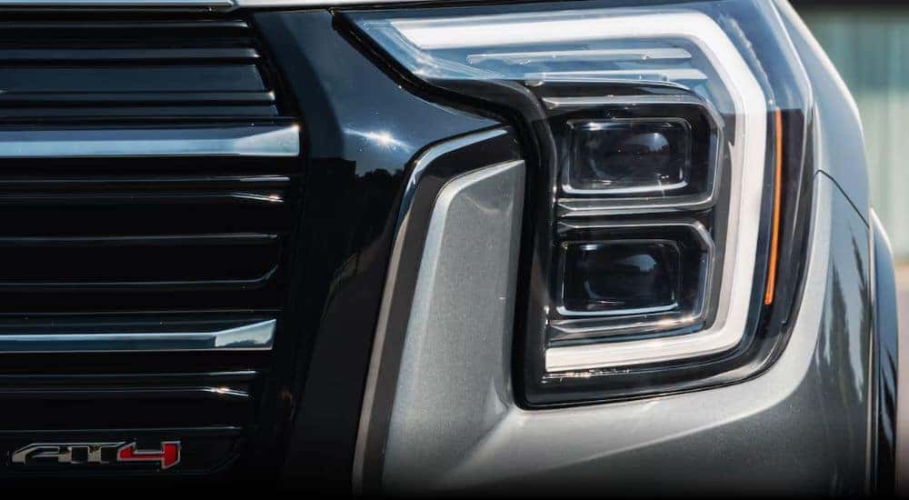 A close-up of the headlight on a 2025 GMC Terrain AT4 is shown at a GMC dealer.