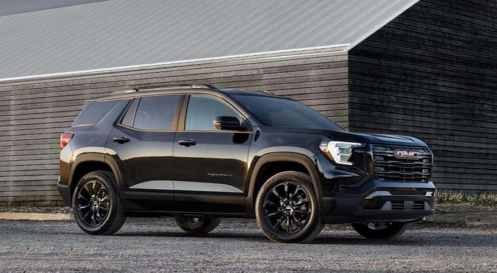A black 2025 GMC Terrain Elevation is shown parked off-road.
