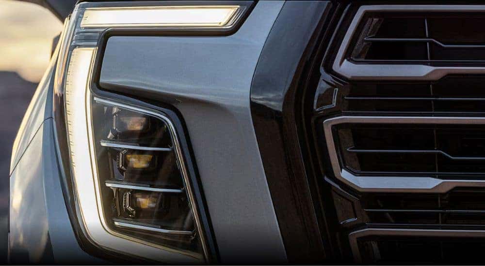 A close-up shows the passenger side headlight on a grey 2025 GMC Yukon after leaving a GMC dealer.