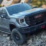 A silver 2024 GMC Sierra 1500 AEV Edition AT4X is shown parked off-road.