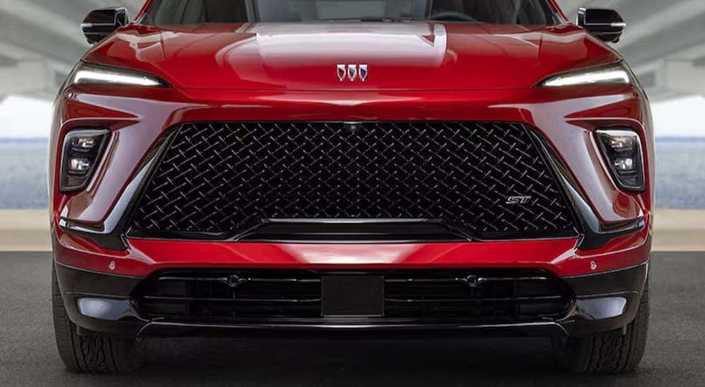 A close-up of the front end is shown on a red 2025 Buick Enclave ST after visiting a Buick GMC dealer near Villa Park.