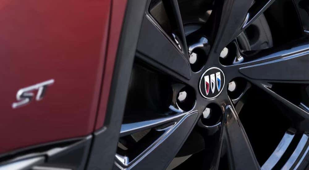 The close-up of a rim on a red 2025 Buick Envision ST.