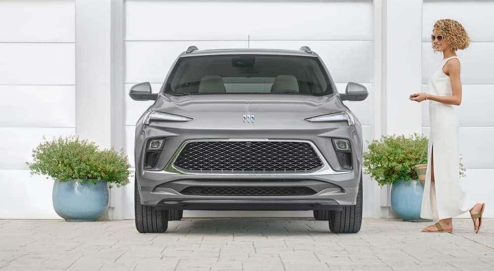 A silver 2025 Buick Encore GX is parked in a driveway after leaving a car dealer.