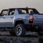 A blue 2025 GMC Hummer EV Pickup is shown parked near an ocean after viewing a Hummer EV for sale.