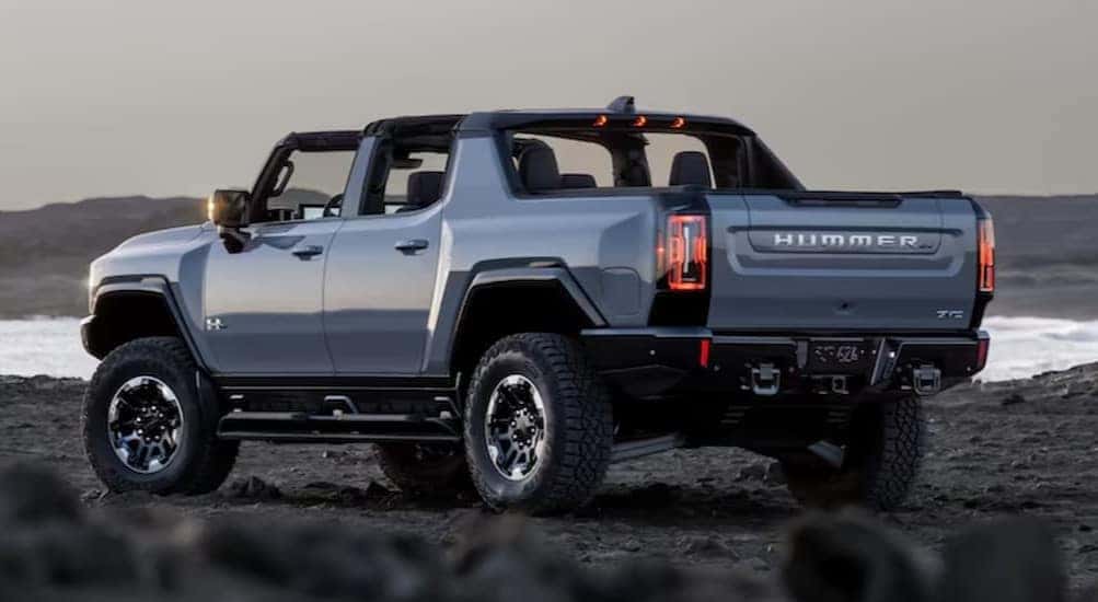 A blue 2025 GMC Hummer EV Pickup is shown parked near an ocean after viewing a Hummer EV for sale.