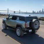 A green 2025 GMC Hummer EV for sale is shown from the rear at an angle.