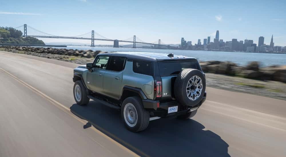 A green 2025 GMC Hummer EV for sale is shown from the rear at an angle.