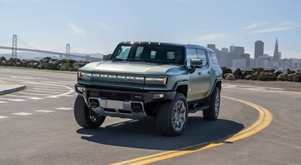 A green 2025 GMC Hummer EV is shown from the front at an angle.