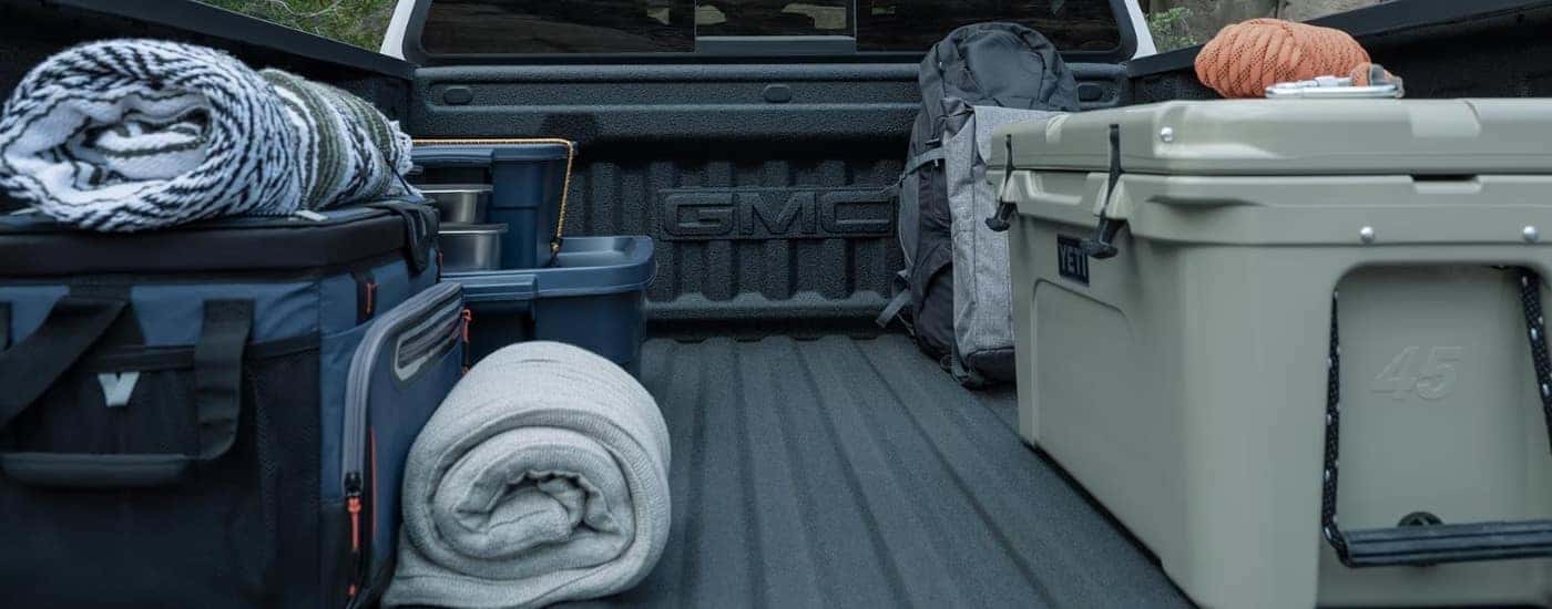 Cargo is shown in the bed of a white 2025 GMC Canyon for sale.