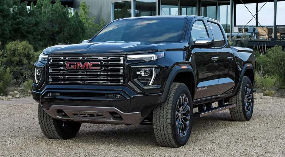 A black 2025 GMC Canyon Denali parked on a driveway.