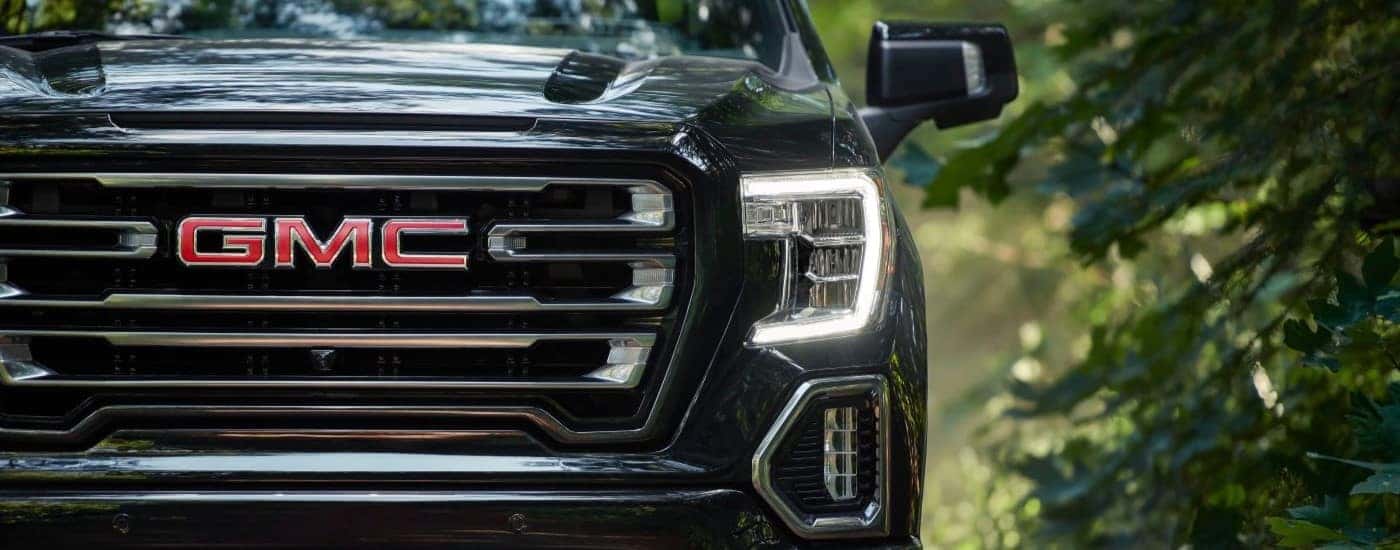 The grille and driver side headlight on a black 2019 GMC Sierra 1500 AT4.