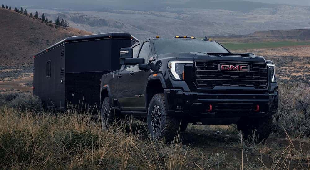 Black 2026 GMC 2500 HD towing a trailer.