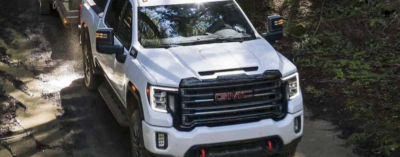 A white 2023 GMC Sierra 2500 HD AT4 driving off-road