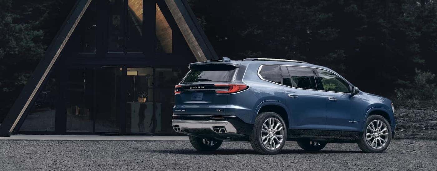 A blue 2025 GMC Acadia from the side.