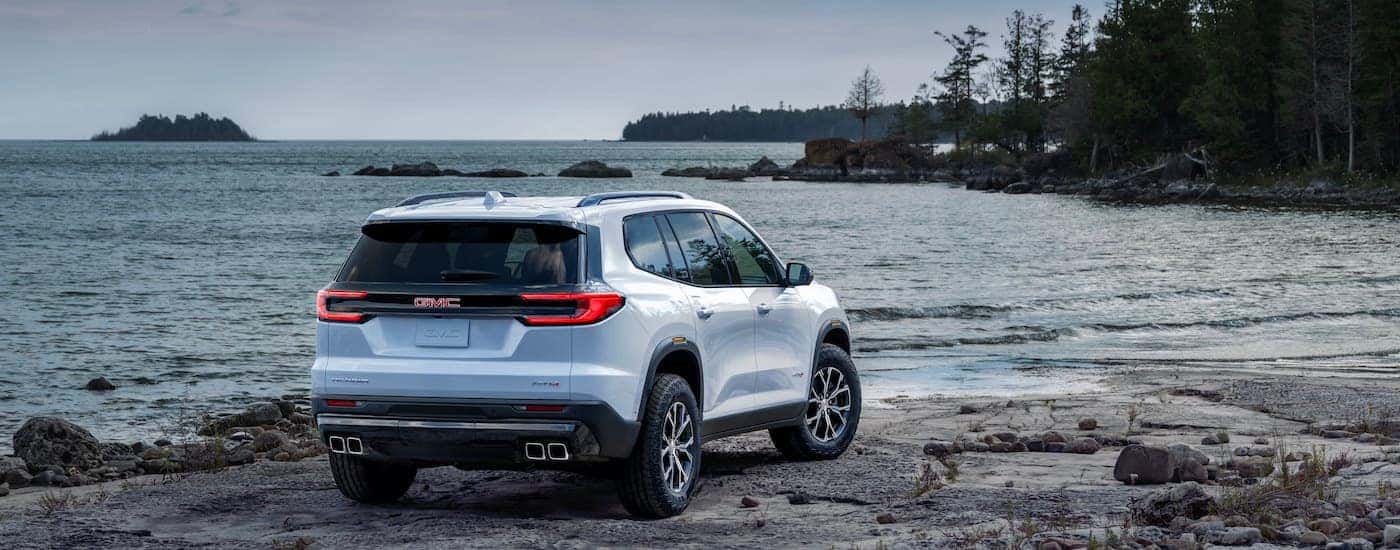 A white 2025 GMC Acadia from the rear at an angle.