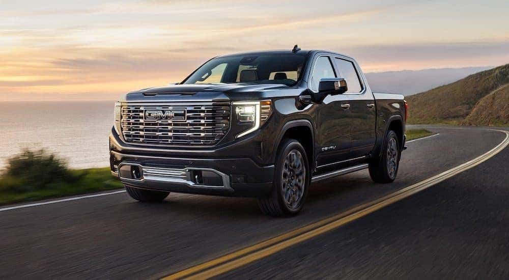 Black 2025 GMC Sierra 1500 driving down a road.