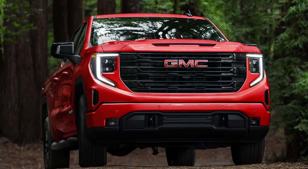 Red 2026 GMC Sierra 1500 for sale near Geneva driving off-road.