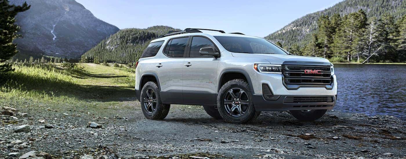 White 2023 GMC Acadia parked by a river