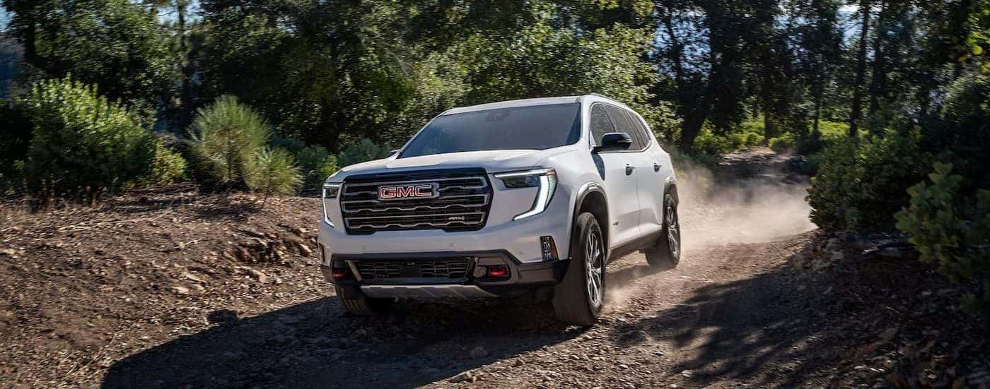 A white 2026 GMC Acadia AT4 off-roading.