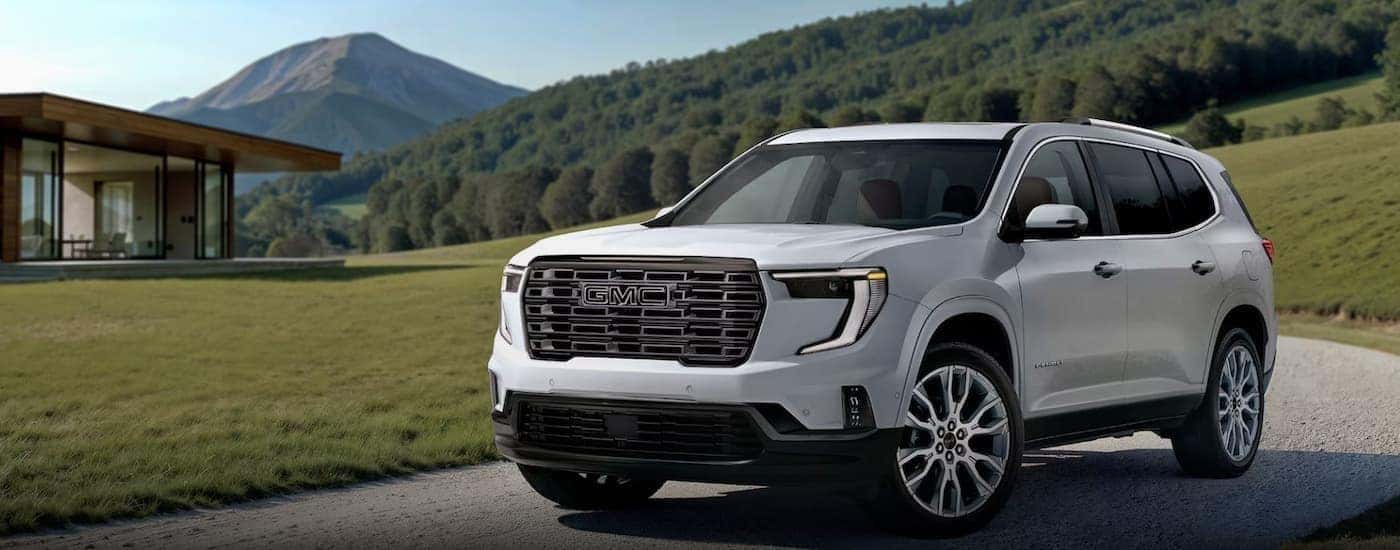 A white 2026 GMC Acadia Denali parked on a driveway.