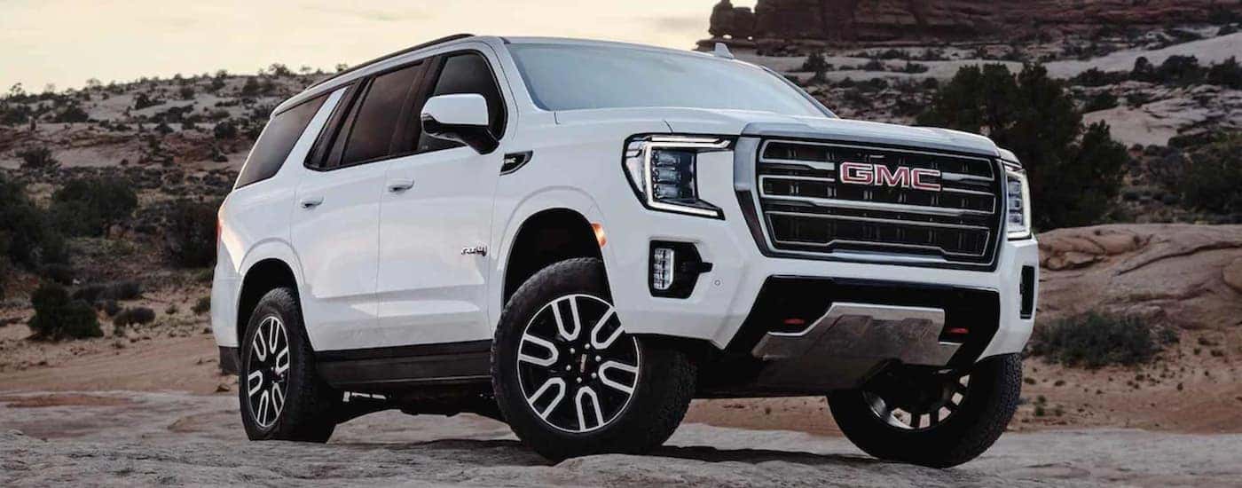 A white 2022 GMC Yukon AT4 shown parked on a rocky road.