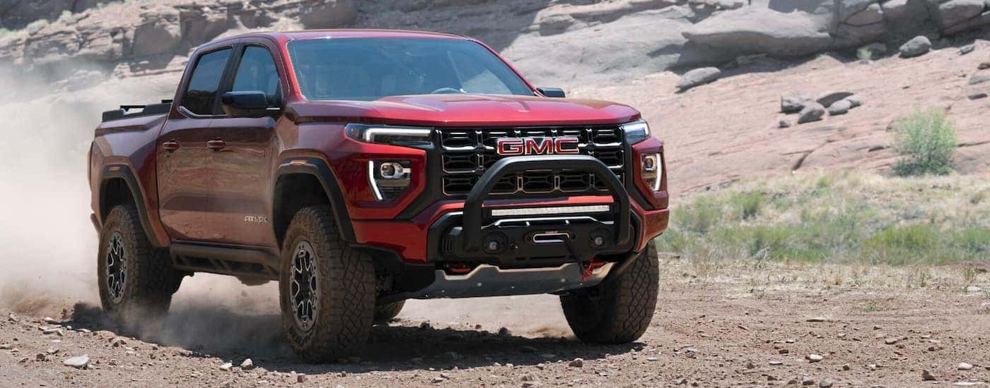 A red 2023 GMC Canyon AT4X off-roading.