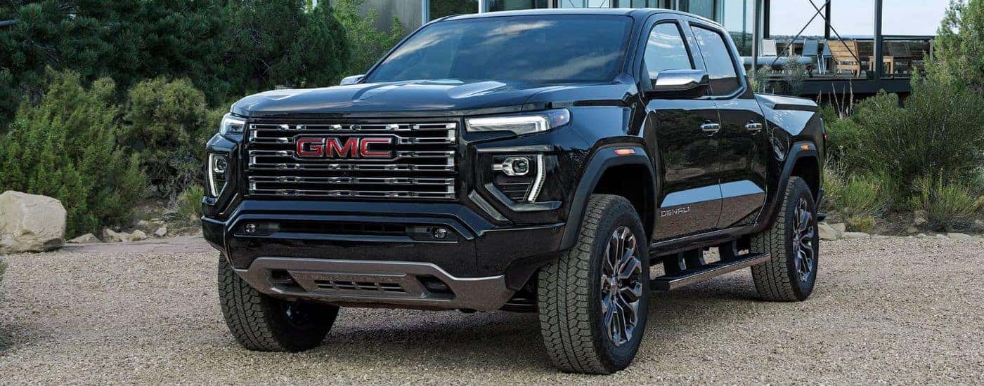 A black 2026 GMC Canyon Denali shown parked on a gravel driveway.