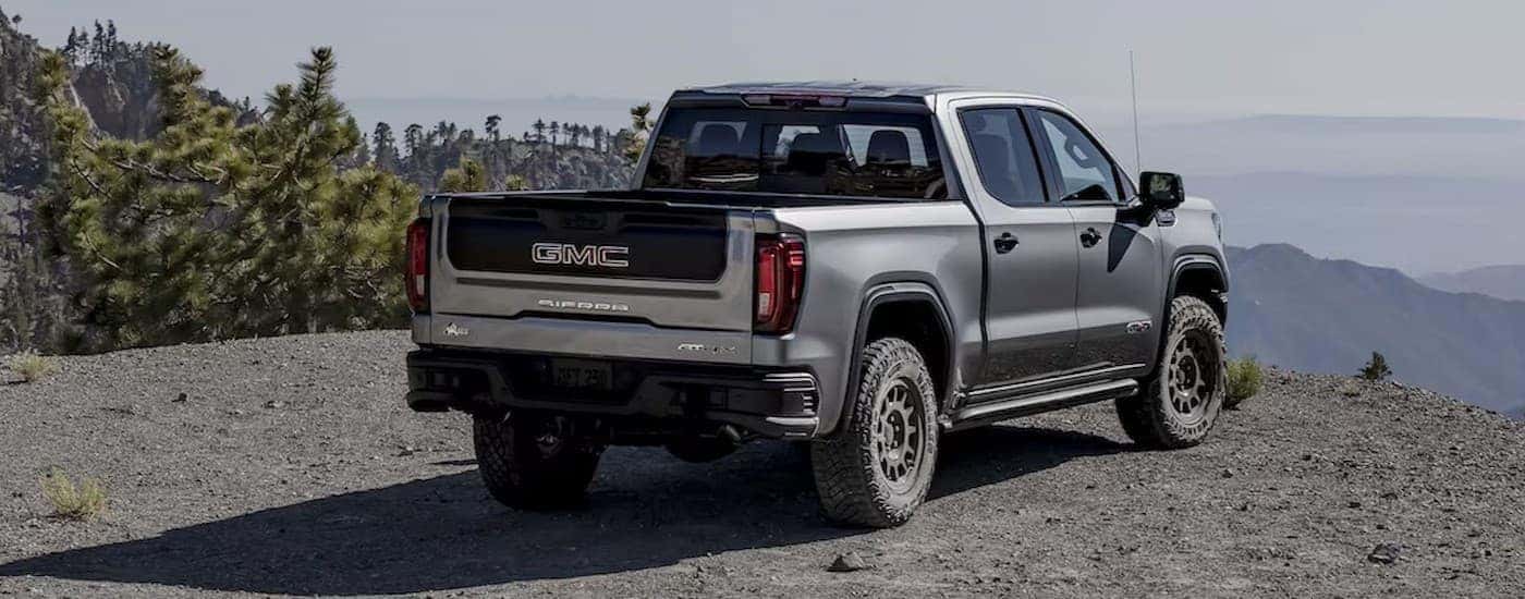 A silver 2025 GMC Sierra 1500 AT4X parked near a cliff.