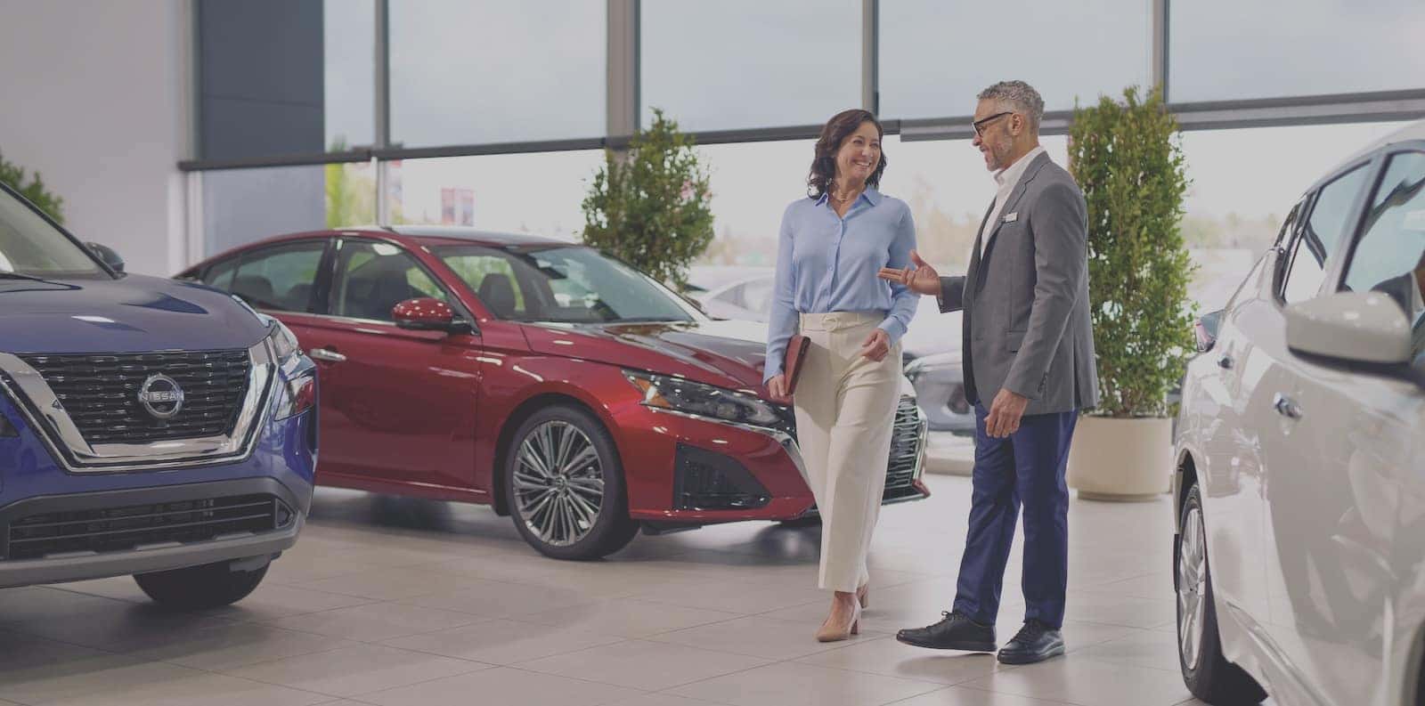 Business owner standing beside their Nissan vehicle