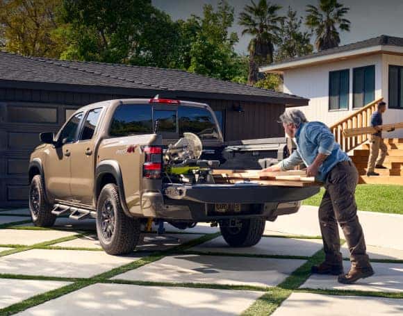 Contractor loading equipment into a Nissan work truck
