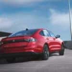 Red Honda Accord driving up a road