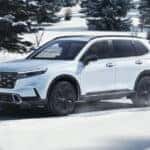 2025 Honda CR-V in white driving on a snowy road