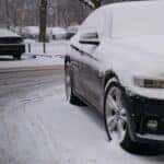 a car covered in snow on a snowy street