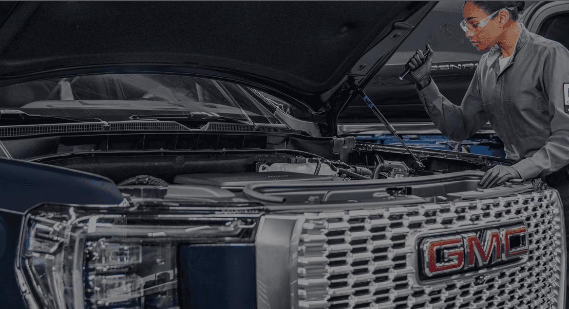 A GMC truck in the service bay at Jay Buick GMC in Bedford, Ohio, with a technician performing a multi-point inspection