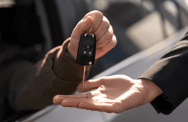 Picture of 2 hands with car keys being transferred between the 2.