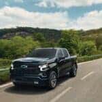 2026 Silverado 1500 RST driving down the open summer road.