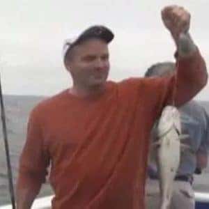 veteran holding a fish he caught by the line