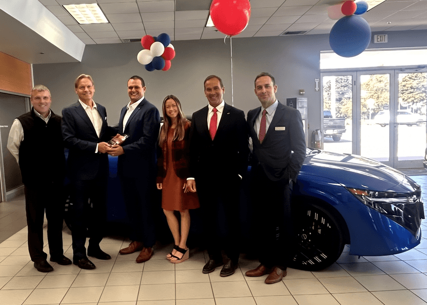 2026 Nissan Award of Excellence Goes to Kelly Nissan of Lynnfield Nissan Team at Kelly Nissan of Lynnfield in front of Nissan Sentra