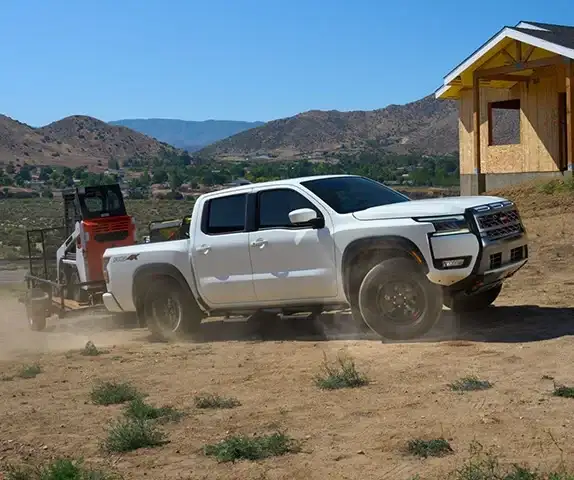2026 Nissan Frontier towing at job site -- 7150 lbs capacity